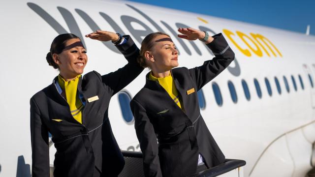 Dos tripulantes de Vueling posand elante de un avión de la compañía