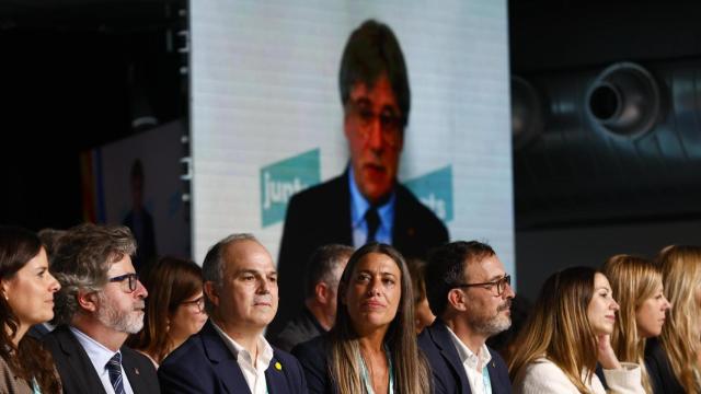 La nueva dirección de Junts escucha la intervención de Carles Puigdemont (en las pantallas) durante el congreso de Calella