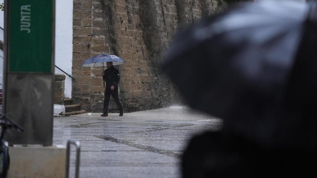 Transeúntes bajo sus paraguas durante la lluvia en Cádiz