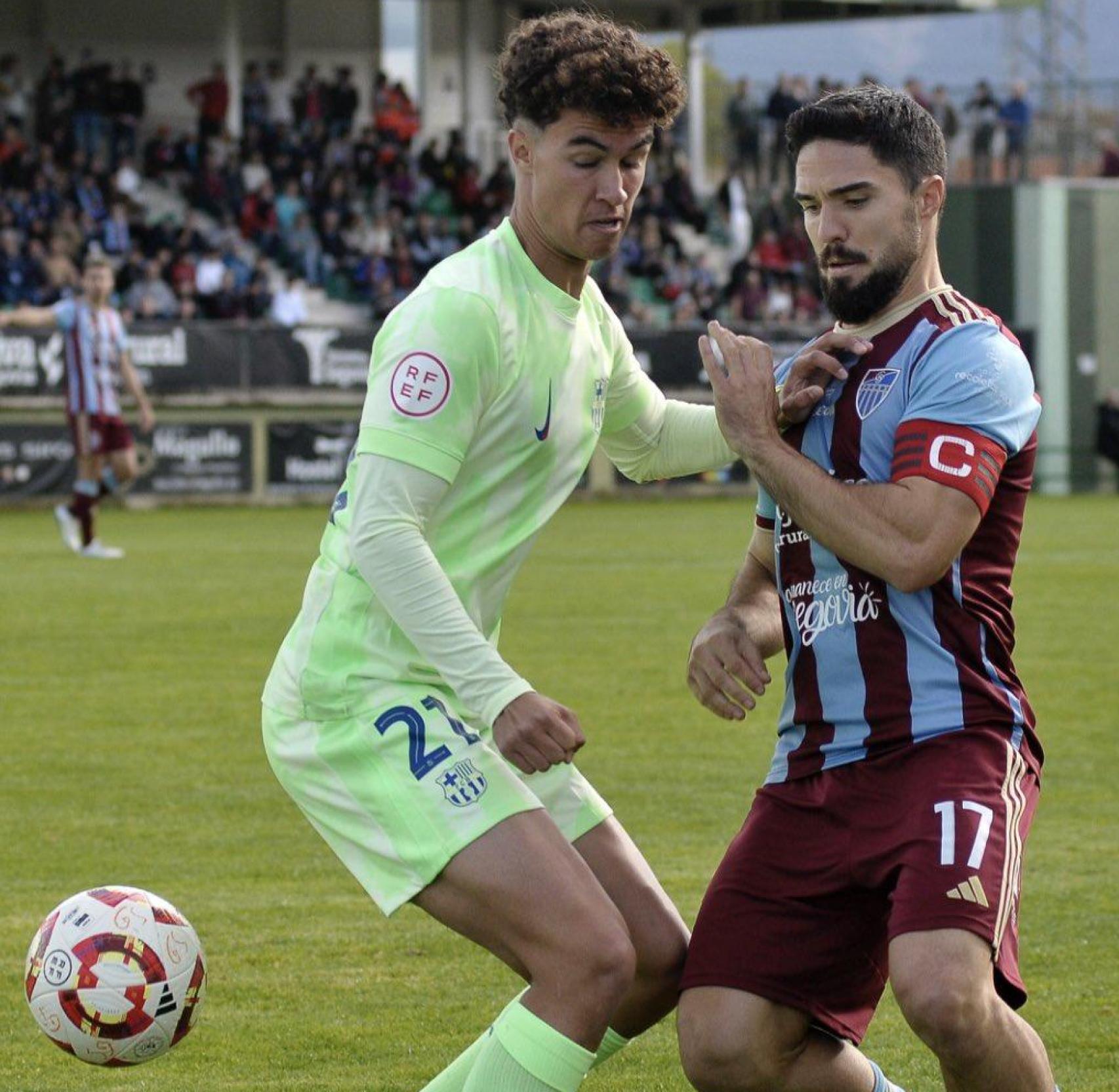 Noah Darvich pugna por el balón con Chupo en el Barça B-Gimnástica Segoviana