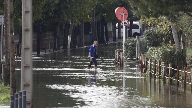 Un vecino, cruzando una calle anegada de Castelldefels ayer