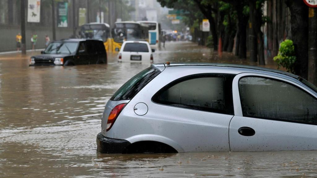 Una imagen de archivo de unos coches en una inundación | CANVA