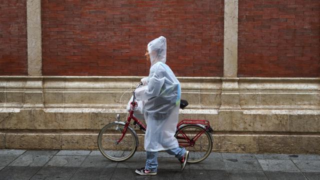 Imagen de una mujer caminando bajo la lluvia