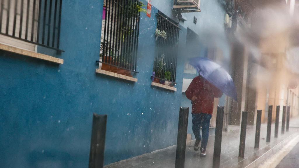 Un hombre se refugia de la lluvia de la DANA en Badalona