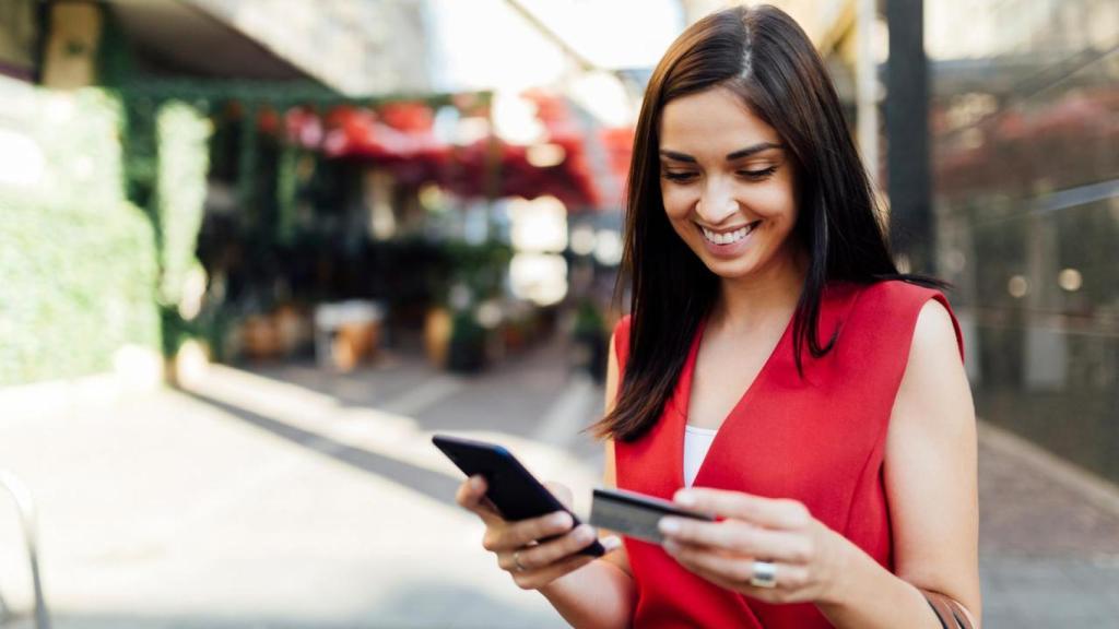 Una joven utiliza su aplicación de móvil para acceder a  la banca digital