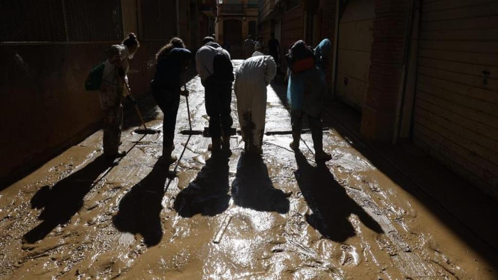 Voluntarios limpiando barro en una calle de Paiporta (Valencia)