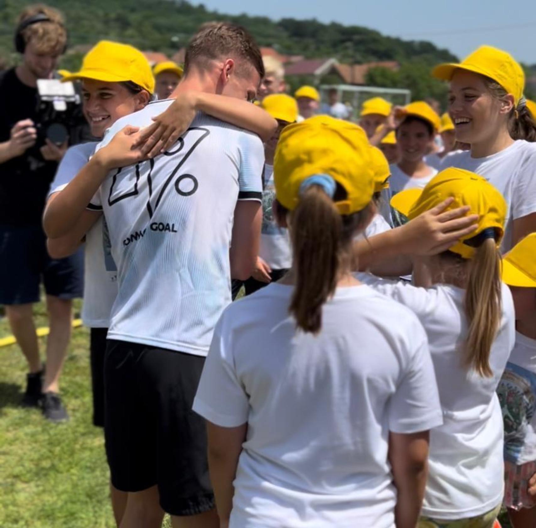 Dani Olmo abraza a un niño en una escuela de la Asociación de Proyectos Interculturales