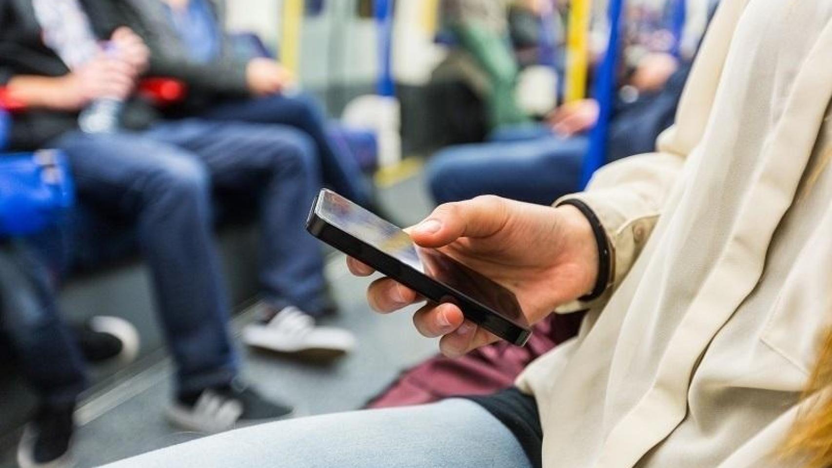 Una mujer usando redes sociales en el transporte público