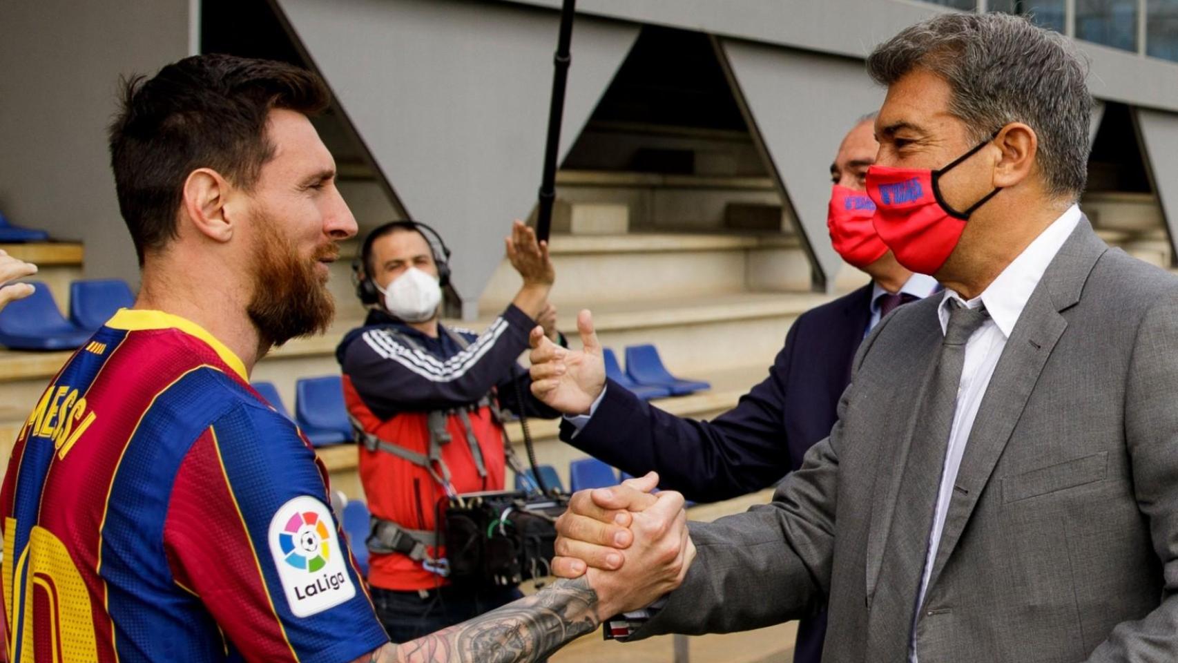 Leo Messi da la mano a Joan Laporta