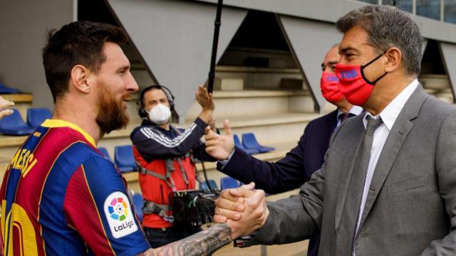 Leo Messi da la mano a Joan Laporta