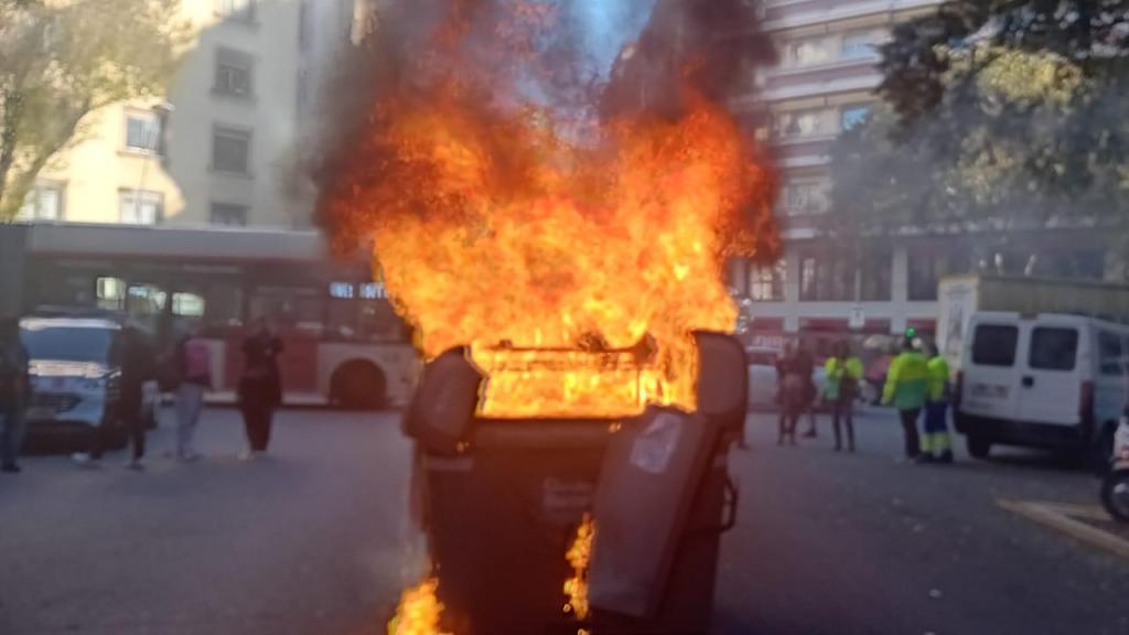 Un contenedor de basura incendiado durante la manifestación de trabajadores de limpieza viaria y recogida de residuos de Barcelona este lunes