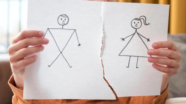 Una niña muestra un dibujo de una pareja rota