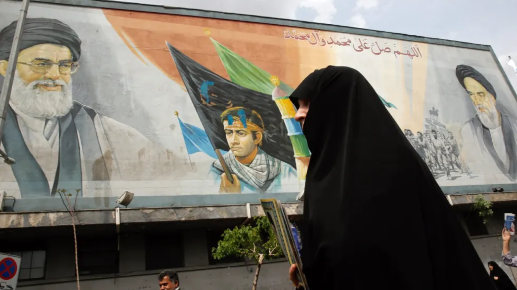 Una ciudadana iraní pasa ante un cartel con el rostro de Homeini, líder supremo