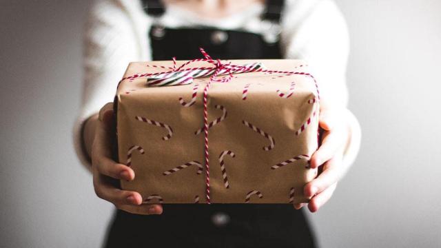 Una persona sujetando uno de los regalos comprados para la Navidad / UNSPLASH