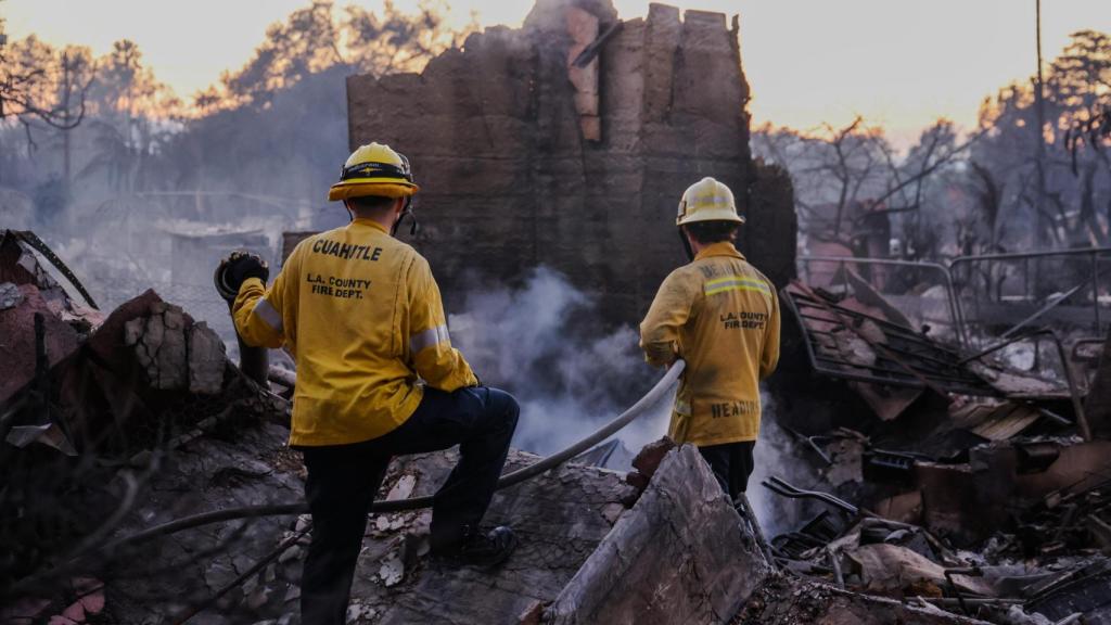 Bomberos en Los Ángeles, en un terreno arrasado por el fuego