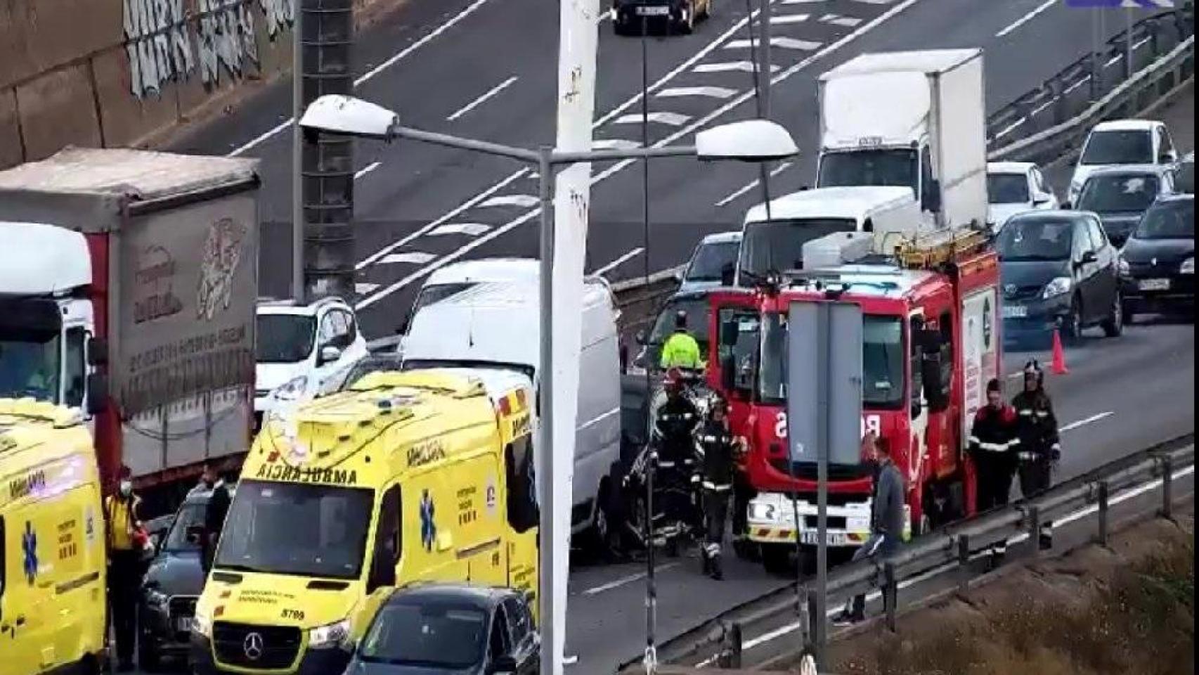 Una ambulancia y bomberos atienden un accidente en la C-58