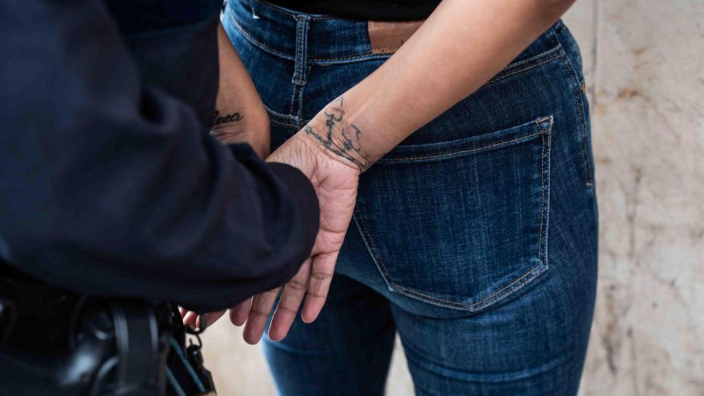 La agentes cacheando a una de las sospechosas