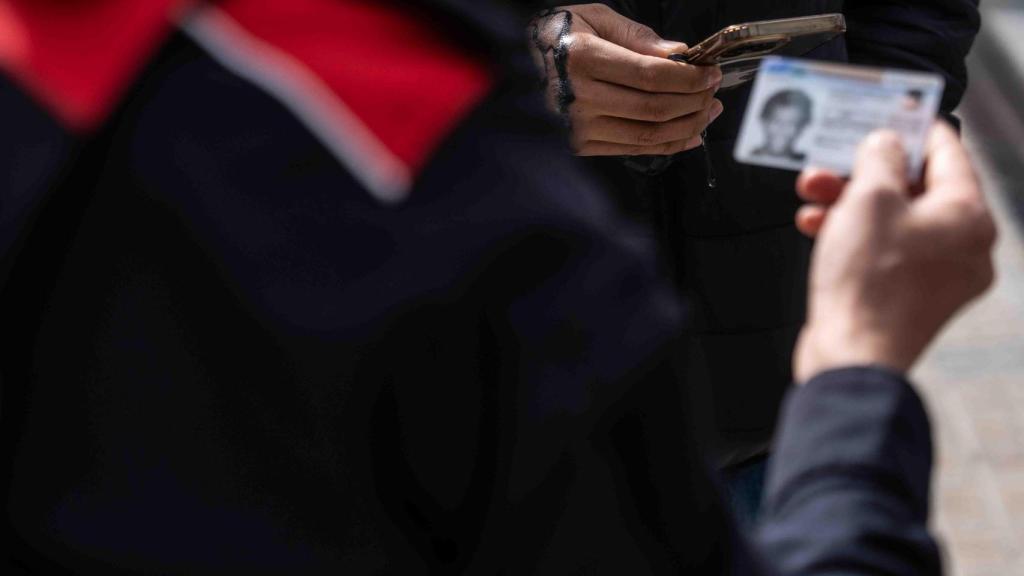 Imagen de archivo de un agente pidiendo la identificación a un sospechoso