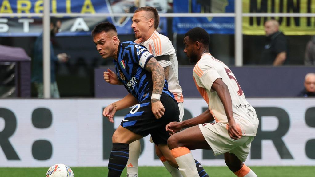Lautaro Martínez pugna con dos defensores en el Inter-Roma de la Serie A