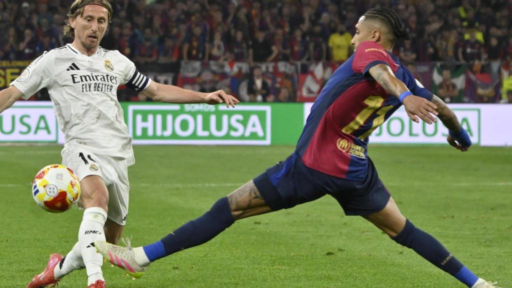 Raphinha intenta robarle el balón a Luka Modric