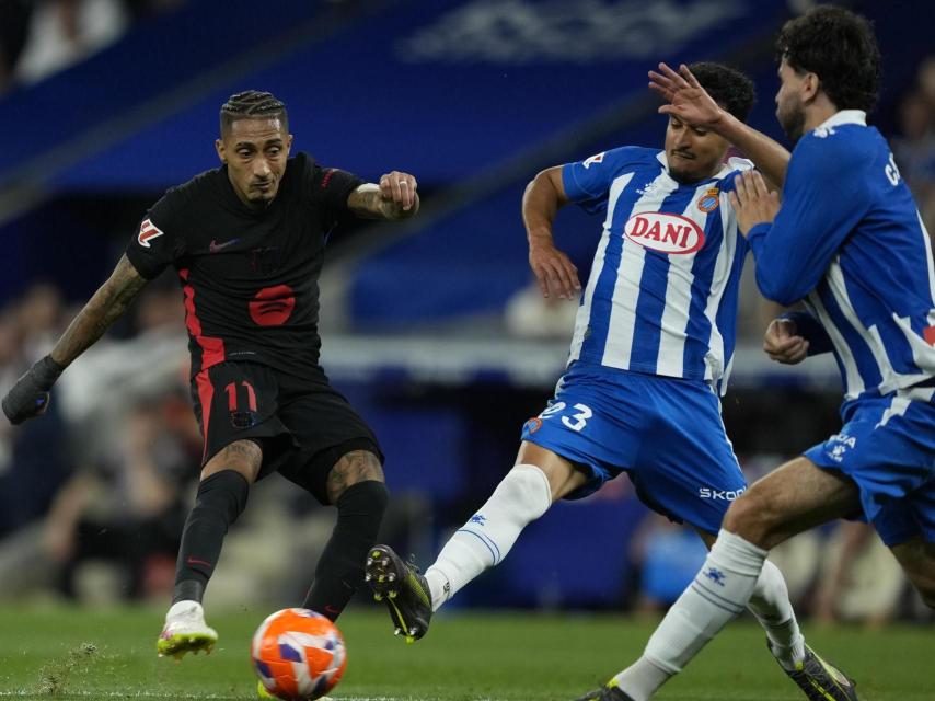 Raphinha remata a portería ante dos futbolistas del Espanyol