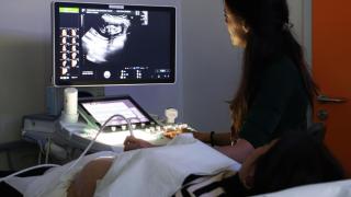 Imagen de una embarazada viendo cómo le hacen una ecografía