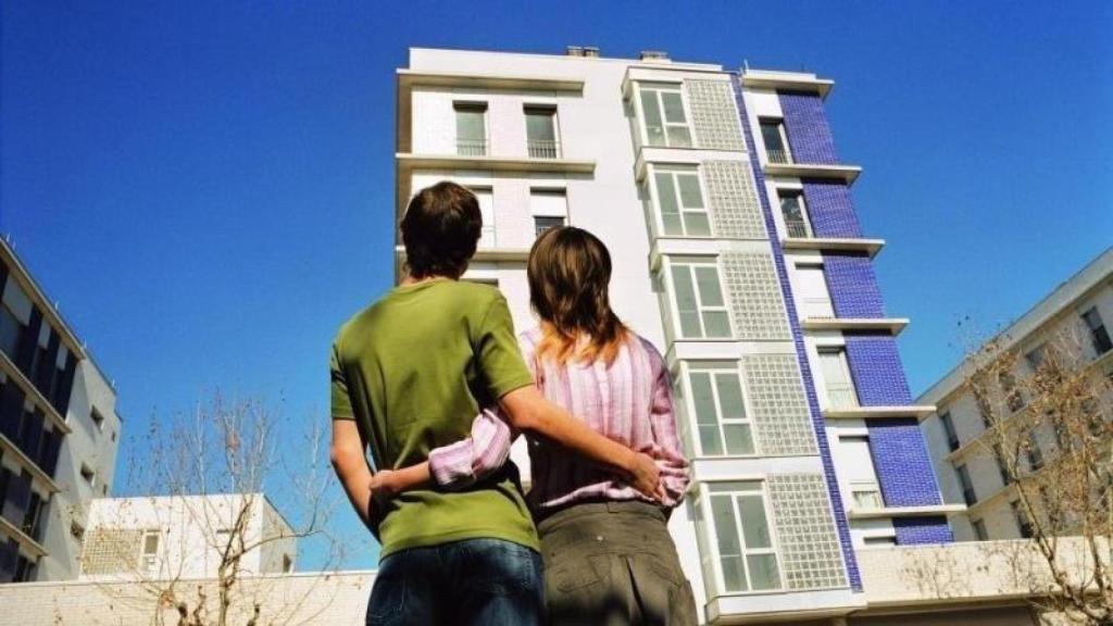 Pareja joven observa unas viviendas de nueva construcción