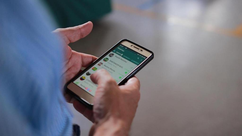 Hombre con un móvil consulta WhatsApp