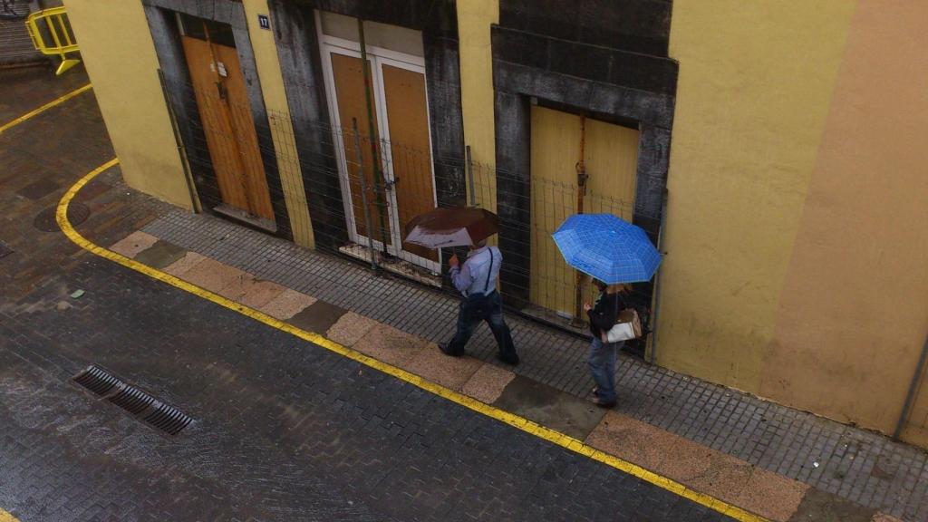 Dos personas se resguardan de la lluvia