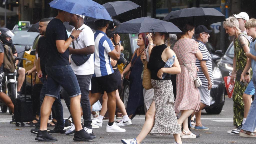 Paseantes por las calles de Barcelona bajo la lluvia