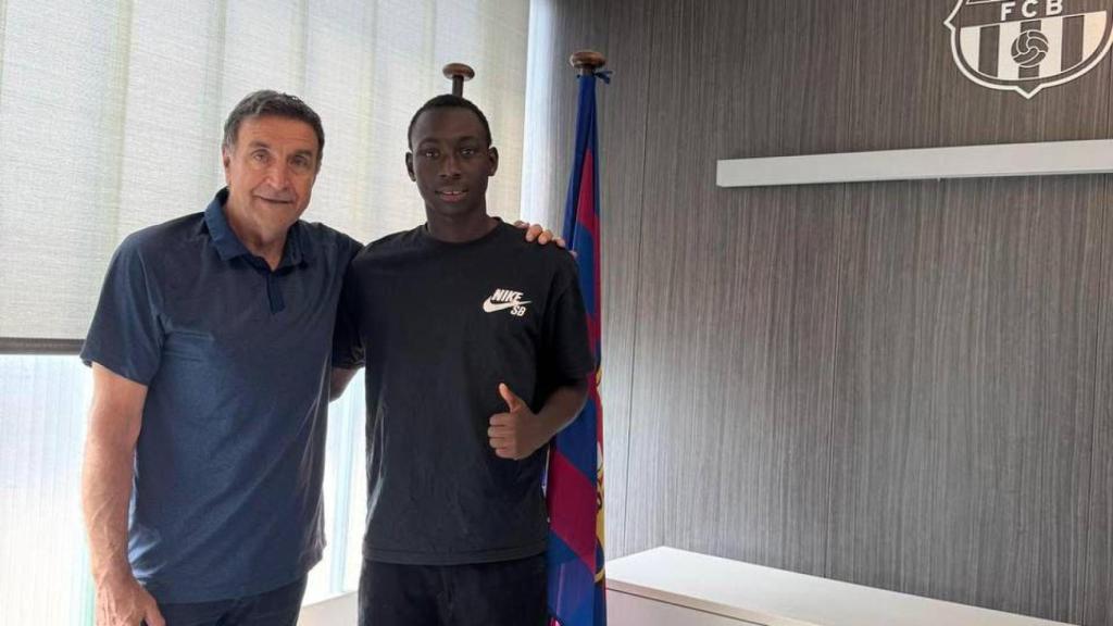 Alieu Drammeh en el acto de firma de su nuevo contrato con José Ramon Alexanco, director de fútbol formativo del FC Barcelona