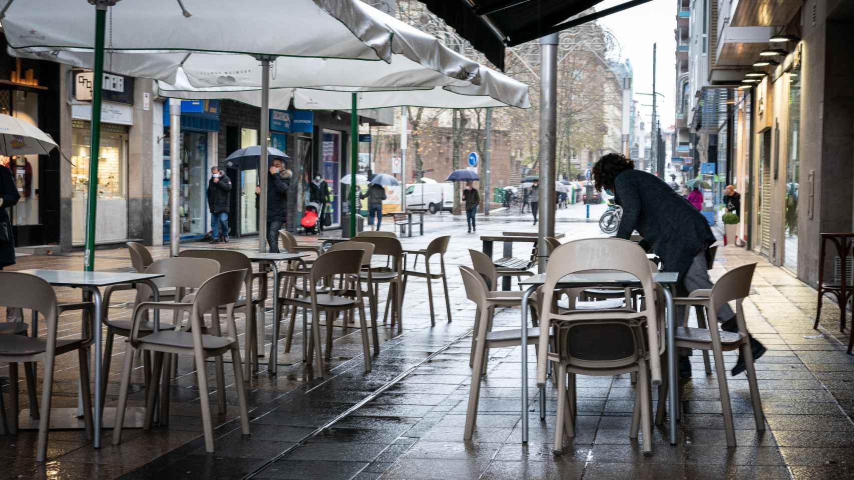 Un hostelero limpia una terraza en un bar de Viroria. EP