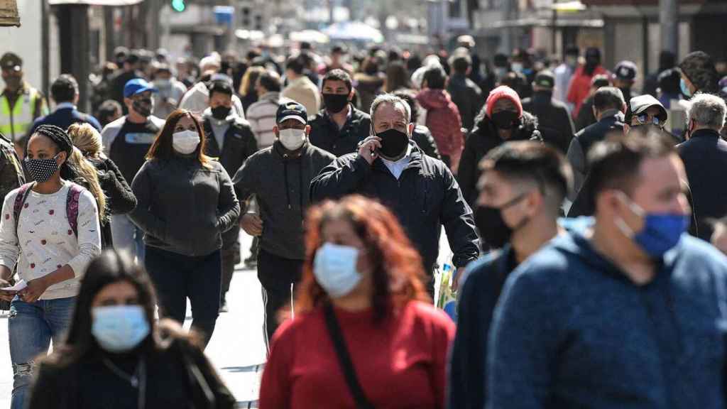 Gente paseando por la calle con la mascarilla. / EP