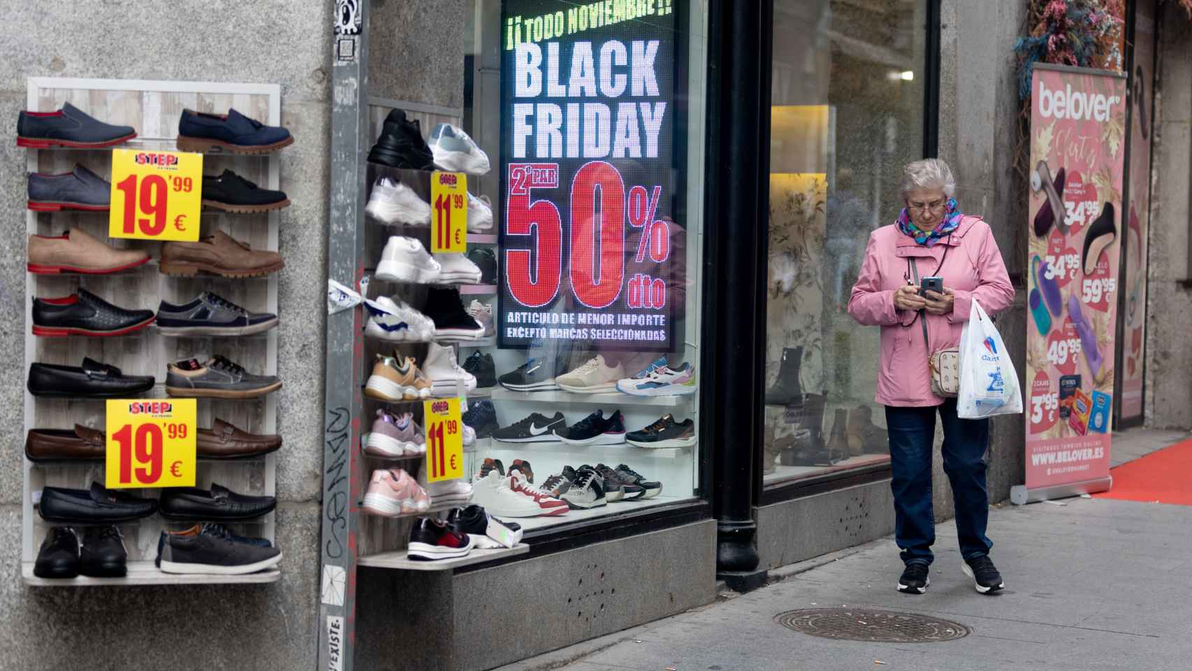 Una mujer pasa por delante de una tienda que anuncia un cartel del Black Friday / EP