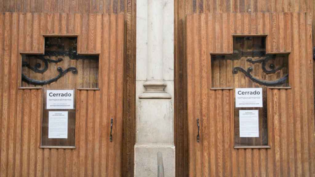 Cruces en la puerta de una iglesia con el cartel de 'Cerrado temporalmente'. /EP