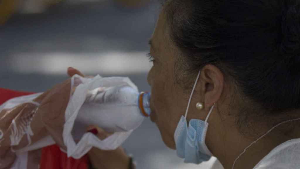 Una mujer bebe agua durante una ola de calor. / EP