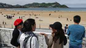 Un grupo de turistas en la playa de la Concha de Donostia. / EFE