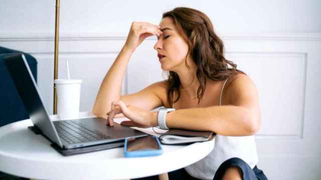 Una mujer muestra signos de cansancio frente al ordenador / PEXELS