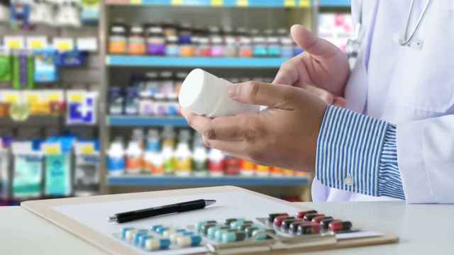 Un farmacutico sostiene un medicamento en una farmacia. / EP