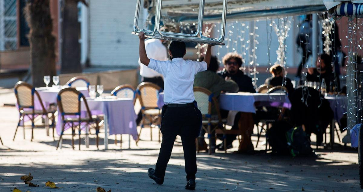 Imagen de un camarero llevando una mesa para montar la terraza / EFE