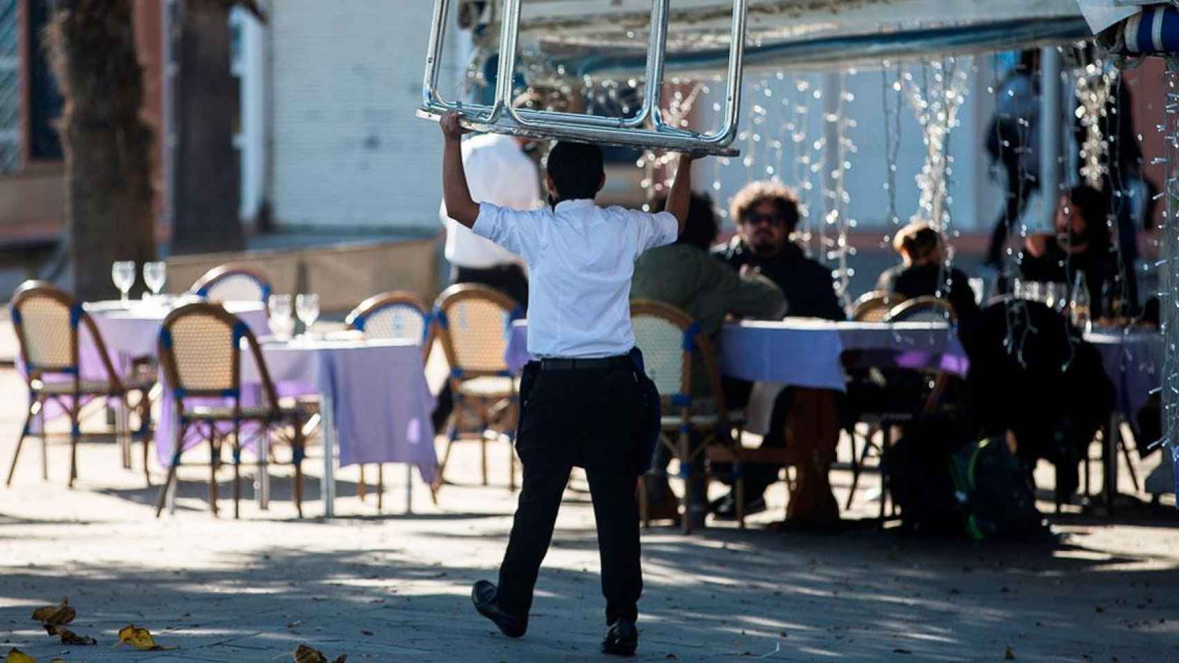 Un trabajador de hostelería llevando una mesa para montar la terraza / EFE