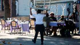 Un trabajador de hostelería llevando una mesa para montar la terraza / EFE