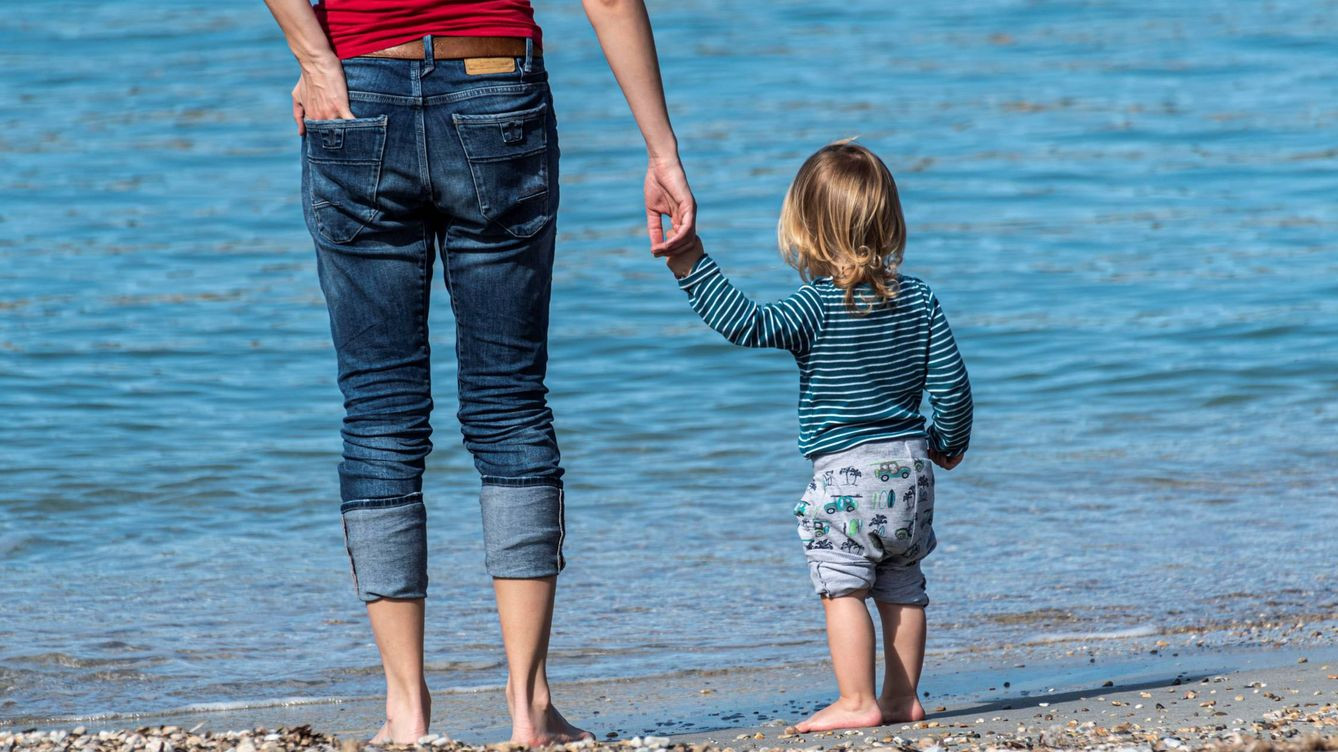 Imagen de una familia, un padre con su hijo pequeño, en la playa. / EFE