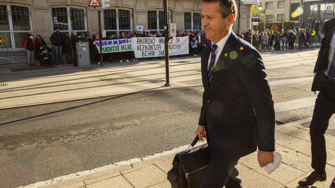 El consejero Bildarratz, a su llegada al Parlamento con la protesta del sindicato Steilas al fondo / David Aguilar (EFE)