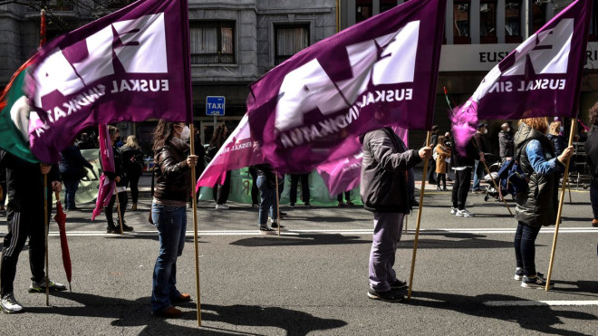 Tres afiliados al sindicato ELA sostienen sus banderas durante la manifestación que ha recorrido las calles de Bilbao este sábado con motivo del Dia del Trabajador. EFE