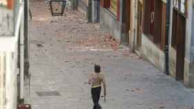 El hombre que se ha atrincherado en su piso en el Casco Viejo de Vitoria, camina por la calle armado con un hacha. / EFE/David Aguilar