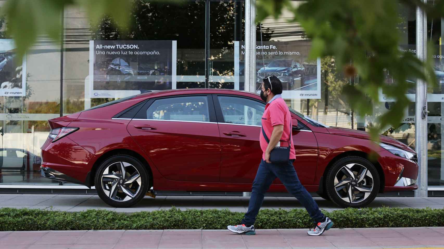 Un hombre observa un coche en un concesionario. / EFE