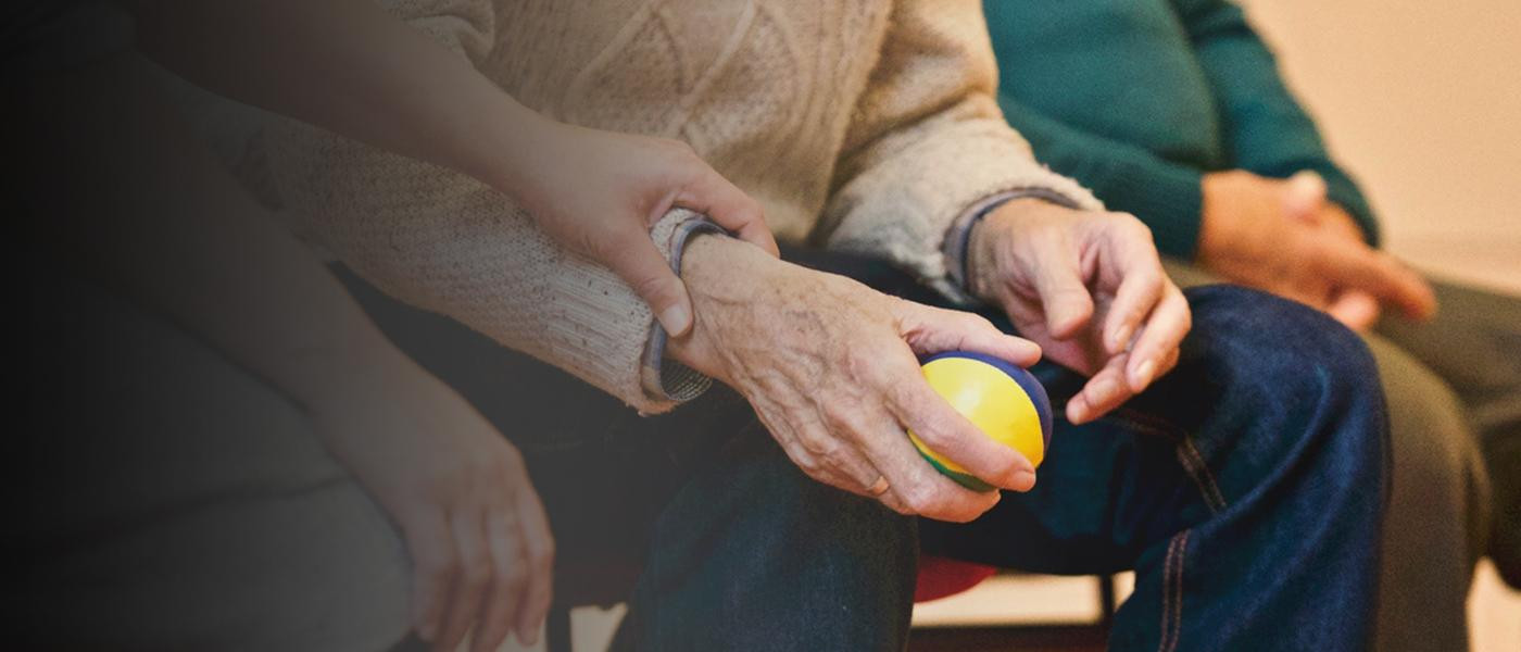 La mano de una cuidadora acaricia la de un anciano con alzheimer / EP (degradado)