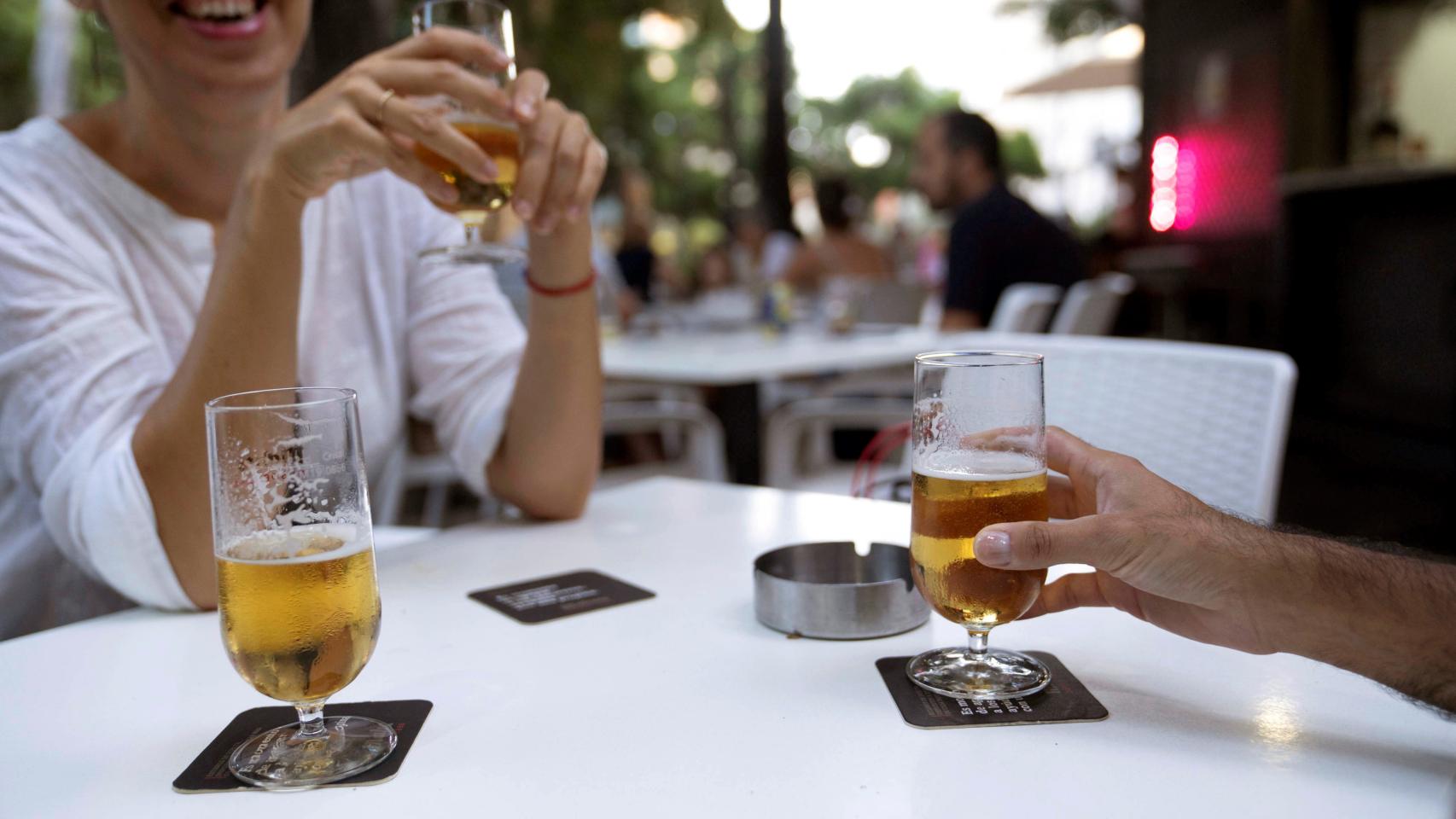 Dos personas consumen cerveza en la terraza de un bar. / EFE