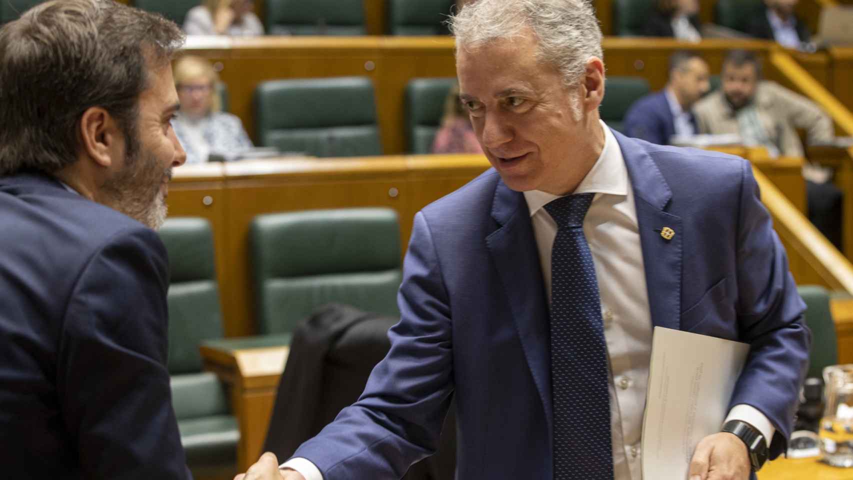 El lehendakari, Iñigo Urkulku (d), saluda al consejero de Comercio, Consumo y Turismo, Javier Hurtado, tras aprobarse en el pleno que celebra este jueves el Parlamento Vasco el Estatuto del Consumidor.